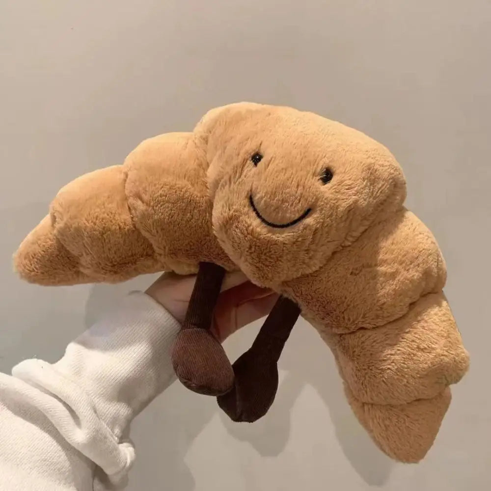 Cojín Peluche Croissant 33 cm – Suave, marrón claro, con carita sonriente
