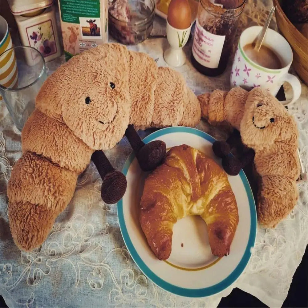 Cojín Peluche Croissant 33 cm – Suave, marrón claro, con carita sonriente